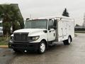 A 2014 International TerraStar truck with a white exterior features a large cargo box on the back and a black grille at the front