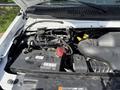 Engine compartment of a 2019 Ford Econoline showing the battery and various components like hoses and fluids