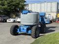 A blue Genie Z 45/25 articulating boom lift with large wheels and a platform for elevated work activities