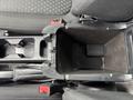 An overhead view of the center console of a 2019 Ford Transit Connect featuring a black storage compartment and cup holders