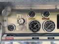 Control panel of a 1999 Freightliner FL80 featuring various pressure and discharge gauges along with operational instructions