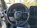 The steering wheel of a 2024 Mercedes-Benz Sprinter 2500 featuring control buttons on the spokes and a prominent Mercedes-Benz emblem in the center