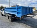 A blue Dodge Ram 5500 flatbed truck with a large blue cargo box attached to the rear