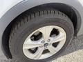 Close-up view of a wheel and tire from a 2014 Ford Escape showcasing a five-spoke aluminum wheel and tread pattern on the tire