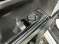 Close-up of the interior door panel of a 2019 Chevrolet Silverado 1500 featuring window and mirror controls with a textured black surface