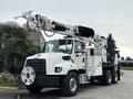 A white 2013 Freightliner 114SD truck with a mounted aerial lift and equipment compartments on the side