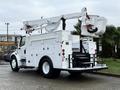 A 2005 Freightliner M2 106 utility truck with a white body and a lift bucket attached to an extendable arm on the back