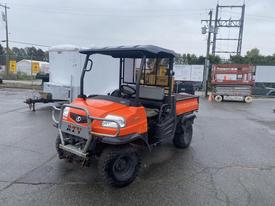 A 2010 Kubota RTV 900 utility vehicle with an orange body and black seating area is parked showing its front and side view