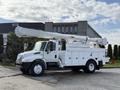 A 2011 International 4300 bucket truck in white with an elevated boom arm and a storage compartment on the side