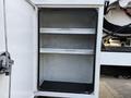 An open storage compartment with two shelves inside a 2013 International Durastar 4300