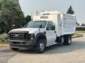 A 2009 Ford F-550 with a white utility box attached to the truck bed showcasing a front view of the vehicle and its distinctive features
