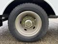 Close-up of a tire on a 2000 Ford F-450 featuring a metallic rim and distinct tread pattern
