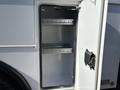 Interior of a truck compartment with open double doors showcasing two metal shelves inside
