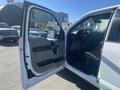 A white 2017 Ford F-150 with the driver's side door open revealing the interior features such as a steering wheel and seats
