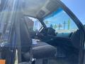 Interior of a 1996 GMC Top Kick showing the driver's seat dashboard and steering wheel with sunlight streaming in through the windshield