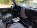Interior view of a 2007 GMC C4500 TopKick featuring black leather seats a dashboard with controls and a console with storage space