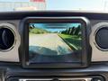 A digital display screen showing a rearview camera view with trajectory lines for a 2021 Jeep Gladiator