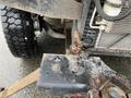 Close-up of a 2012 Workhorse W62 truck showing part of the front suspension and steering components including a rusted metal piece and bolts