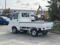 A white 2010 Daihatsu Hijet small truck with a flatbed and cab visible from the rear angle