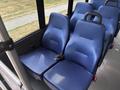 Two blue upholstered seats with seat belts in a vehicle interior designed for passenger transport
