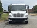 A 2006 Freightliner M2 106 truck with a white exterior and chrome accents visible in the front view showcasing the grille and headlights