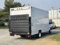 A white 2008 Ford Econoline box truck with a rear ramp and large black loading door