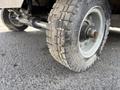 Close-up view of a tire from a 2023 Bitimec SC415 showcasing deep tread patterns and a silver rim