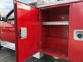 A red storage compartment of a 2013 Chevrolet Silverado 3500HD with an open door revealing empty shelves inside