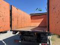 A 2016 Isuzu NPR-HD truck with an open orange cargo box revealing a clean interior with wood flooring and no cargo inside
