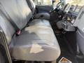 Interior view of a 2017 International 4300 showing a spacious gray bench seat with seatbelts and central console with controls and storage compartments