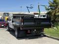 A 2019 Ford F-550 with a flatbed truck design featuring a black bed and tailgate positioned in a parking area
