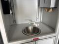 A stainless steel sink with a white faucet inside a cabinet in a 2020 Mercedes-Benz Sprinter 2500