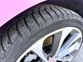 Close-up of a Pirelli tire on a 2020 Jaguar XE showcasing the tread pattern and silver alloy wheel with a Jaguar emblem