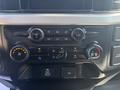 Dashboard controls of a 2023 Ford F-350 SD featuring knobs for volume climate control and air conditioning settings