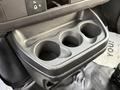A black plastic cup holder with three circular openings designed to hold drinks in a 2015 GMC Savana