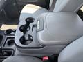 A gray center console with cup holders is visible in the front seat area of a 2013 RAM 2500
