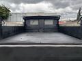 A 2015 Mitsubishi Fuso FE160 featuring a flatbed with a raised black canvas cover and lattice-style side panels