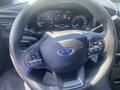Steering wheel of a 2020 Ford Explorer featuring controls for audio and cruise settings along with the Ford logo in the center