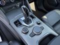 Interior view of a 2020 Alfa Romeo Stelvio showcasing the gear shifter and control knobs on the center console