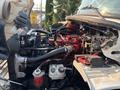 A 2016 Freightliner M2 106 engine compartment showcasing various components including hoses wires filters and a red engine block