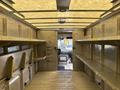 Interior of a 2012 Ford Econoline van with metal shelves on both sides and a clear view of the front cabin