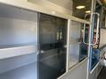 A 2011 Chevrolet Express with empty glass-fronted cabinets and metal shelves in the interior