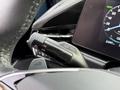 A close-up view of the steering wheel control stalk featuring buttons for headlights and turn signals in a 2023 Kia Niro EV interior