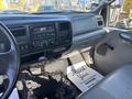 Interior of a 2004 Ford F-750 featuring a dashboard with audio controls and air vents along with a manual transmission gear shift and a floor mat with a thank you message