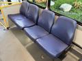 A row of three blue upholstered bus seats with a smooth texture and a sturdy frame