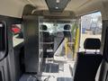 Interior view of a 2021 RAM Promaster featuring a single gray seat and a transparent partition separating the driver area from the rest of the van