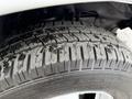 A close-up of a tire from a 2020 Chevrolet Express showing tread patterns and slight wear on the rubber surface