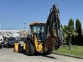 A 2013 John Deere 710K backhoe loader with a yellow and black exterior featuring a front bucket and a rear excavator arm