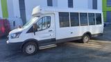 A white 2021 Ford Transit with a passenger side door and multiple windows designed for transporting people