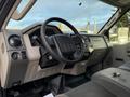 The interior of a 2010 Ford F-550 featuring a steering wheel dashboard controls and gear shift with keys on the front seat